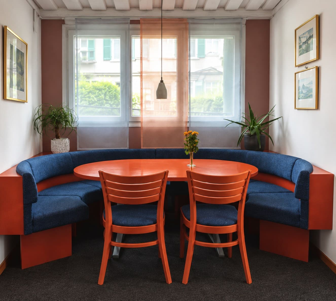 Vorher: Gastro-Sitzecke mit blauer Rundbank, orangen Stühlen und orangem Tisch